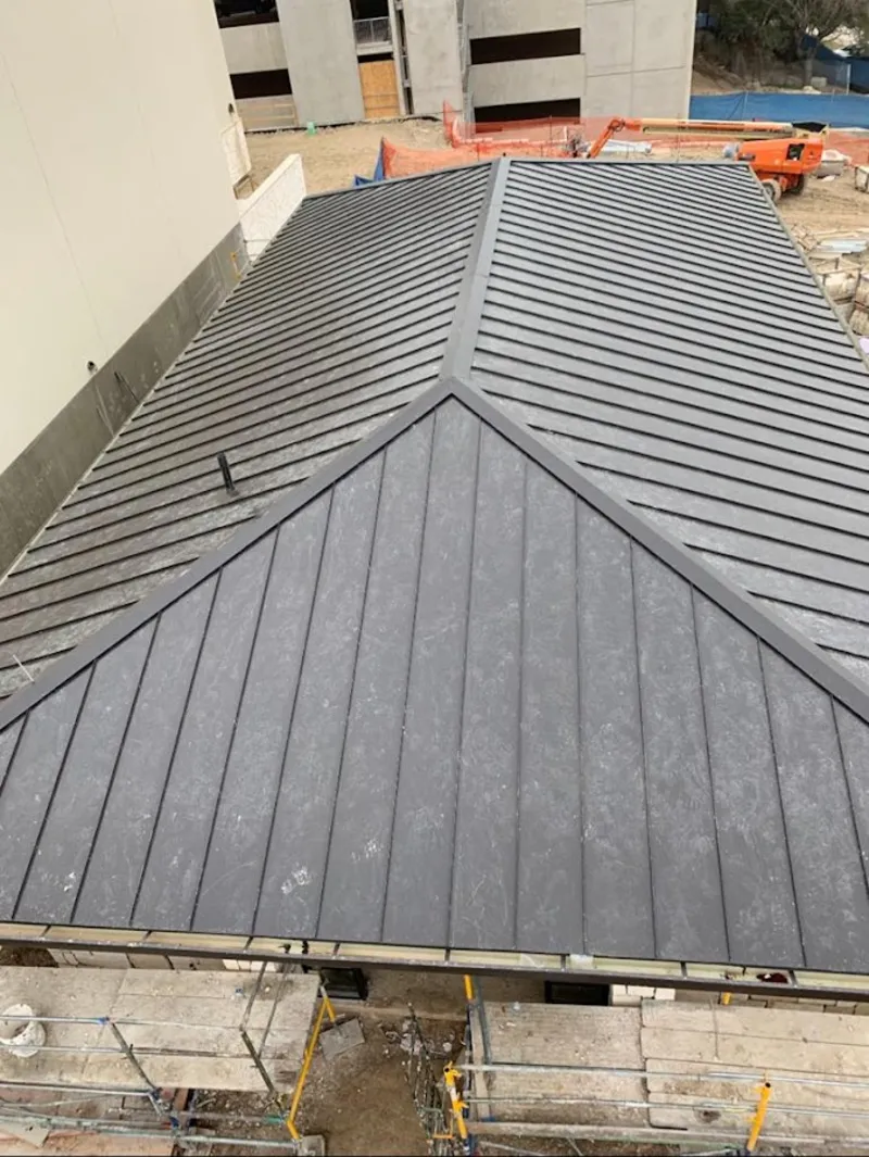 Commercial metal roof construction with crane equipment in Champlin